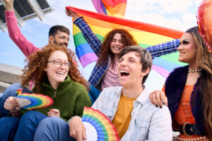 Diverse young friends cheerful group celebrating gay pride festival day together. LGBTIQ community. Diverse young friends cheerful group celebrating gay pride festival day together. Five smiling people from LGBT community having fun outdoor. Lesbian, homosexual, transgender and non-binary.